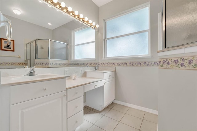 bathroom featuring double vanity, a stall shower, tile patterned flooring, and a sink