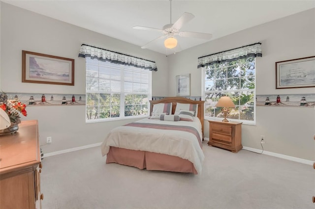 bedroom with light carpet, ceiling fan, and baseboards