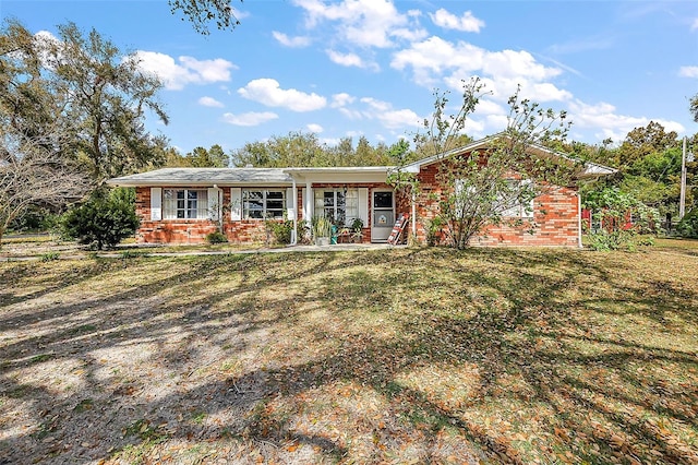 ranch-style house featuring brick siding and a front yard