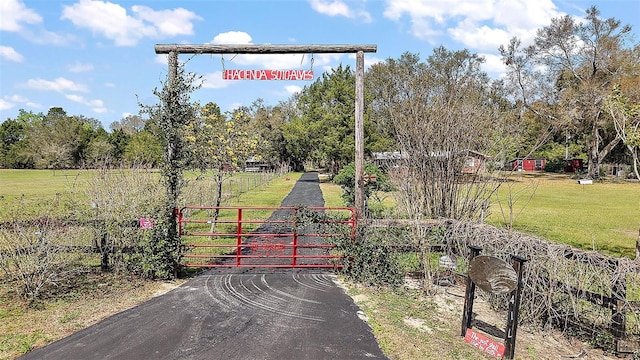 view of gate featuring a yard