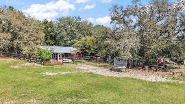 view of yard featuring an exterior structure, a rural view, and an outdoor structure