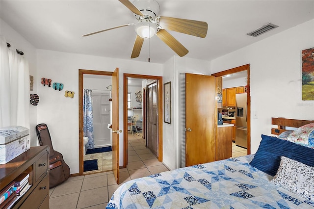 bedroom featuring light tile patterned floors, visible vents, a ceiling fan, and stainless steel refrigerator with ice dispenser