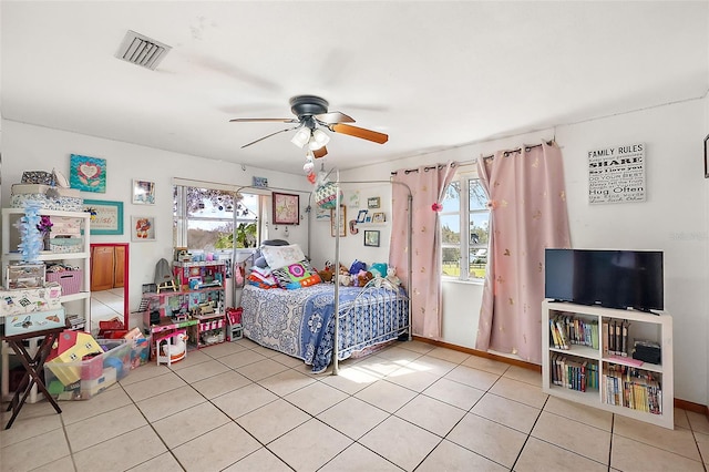 bedroom featuring ceiling fan, visible vents, multiple windows, and light tile patterned flooring