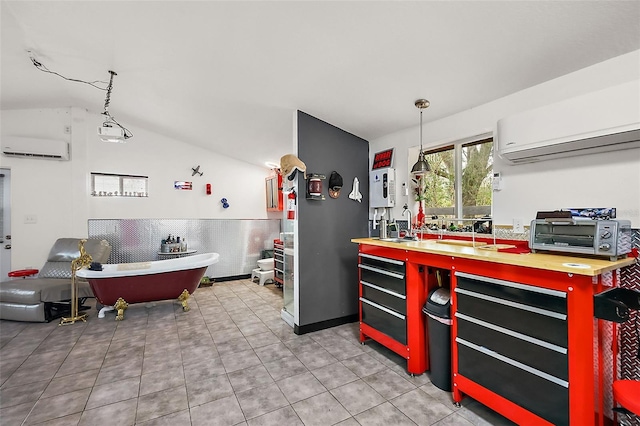 kitchen featuring tile patterned flooring, a wall unit AC, a toaster, and vaulted ceiling