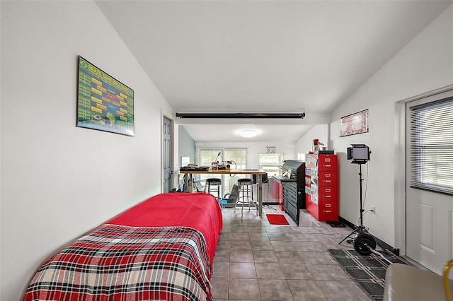 tiled bedroom featuring vaulted ceiling