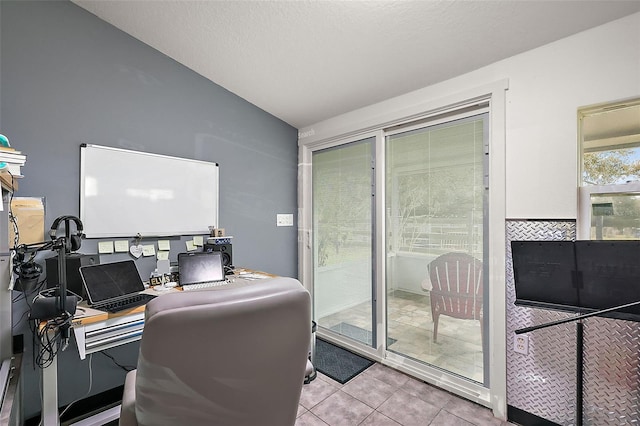 home office featuring tile patterned floors and vaulted ceiling