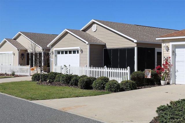 view of front facade featuring driveway, a shingled roof, an attached garage, and fence