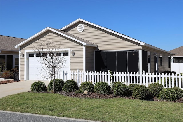 view of front of house featuring a front lawn, fence, driveway, and an attached garage