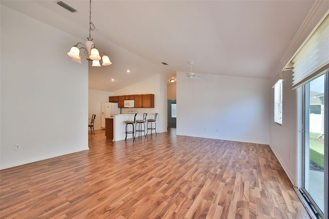 unfurnished living room with vaulted ceiling, baseboards, visible vents, and light wood-style floors