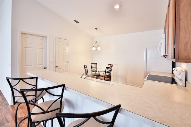 dining room with lofted ceiling, light wood-style flooring, recessed lighting, a notable chandelier, and visible vents