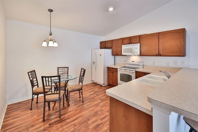 kitchen with white appliances, brown cabinetry, light countertops, a chandelier, and a sink