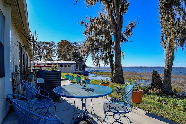 view of patio featuring central air condition unit and a water view