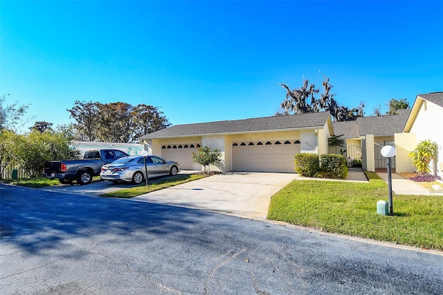 ranch-style home featuring stucco siding, an attached garage, and concrete driveway