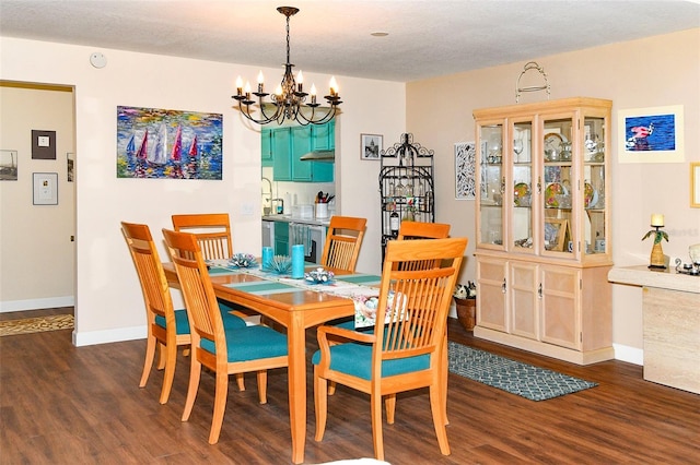 dining area featuring an inviting chandelier, dark wood-type flooring, baseboards, and a textured ceiling