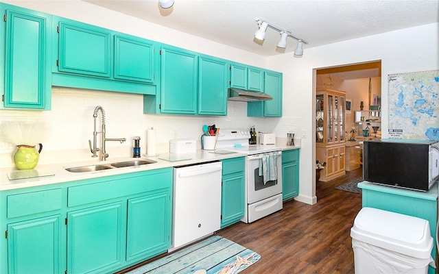 kitchen with a sink, under cabinet range hood, backsplash, white appliances, and light countertops