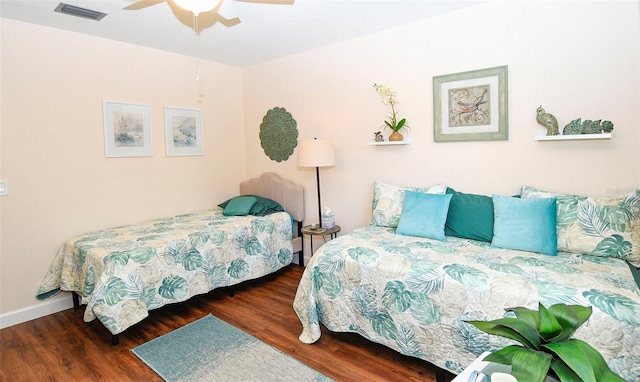 bedroom with a ceiling fan, wood finished floors, visible vents, and baseboards