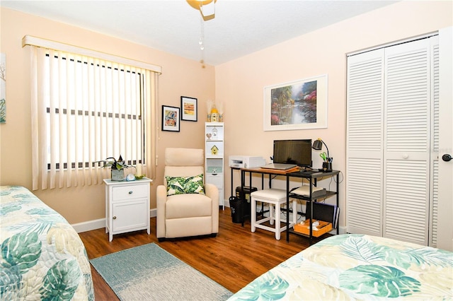 bedroom with a closet, baseboards, and dark wood finished floors