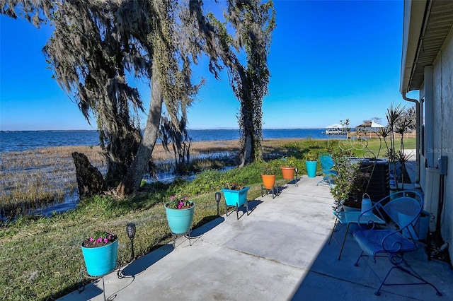 view of patio / terrace with central AC and a water view