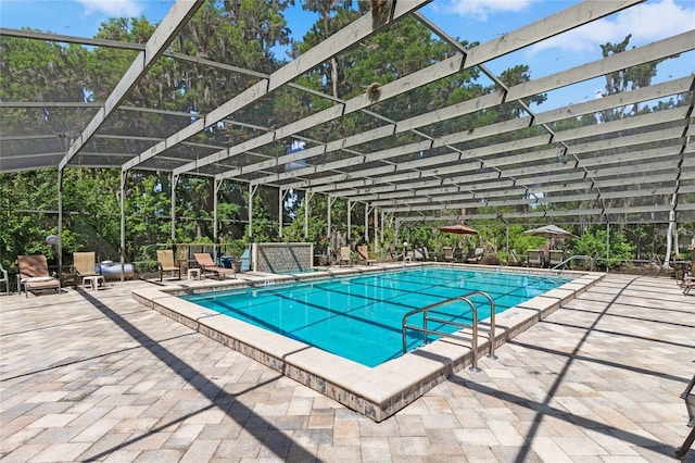 pool featuring glass enclosure and a patio