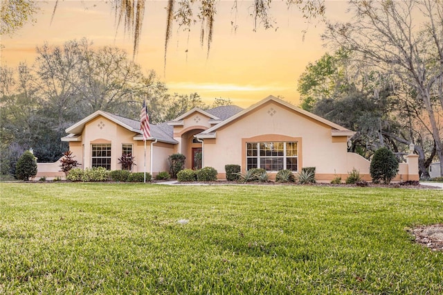 mediterranean / spanish home with stucco siding and a front yard