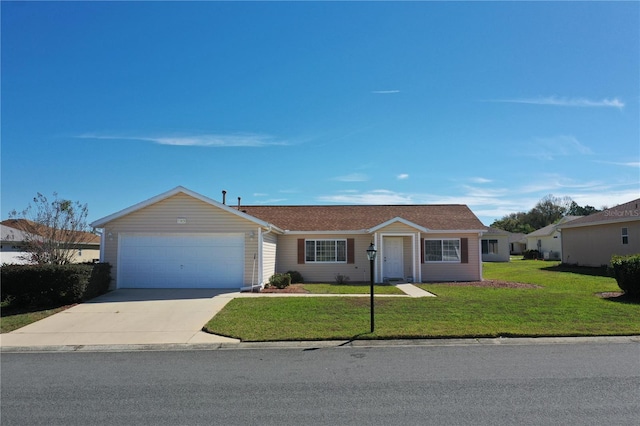 ranch-style home with a garage, concrete driveway, and a front yard