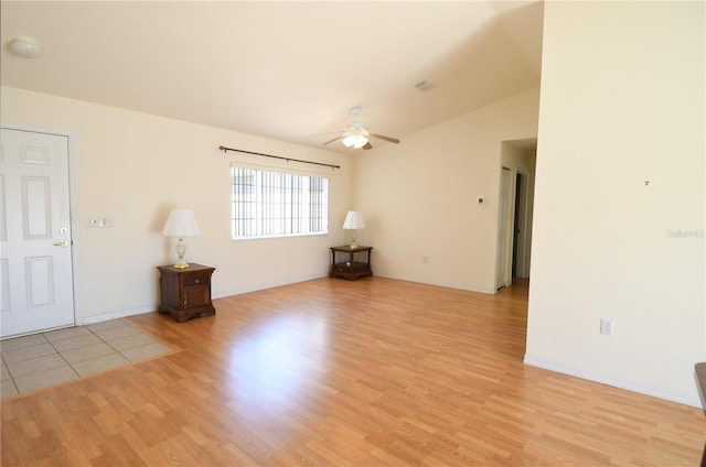 empty room featuring baseboards, a ceiling fan, and light wood finished floors