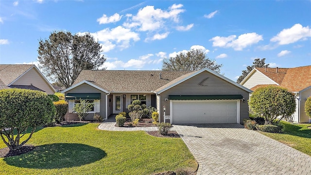 single story home featuring an attached garage, a front lawn, and decorative driveway