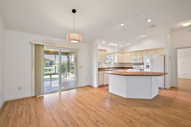 kitchen featuring white appliances, visible vents, lofted ceiling, light wood-style flooring, and hanging light fixtures