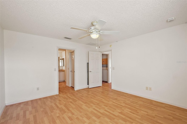 empty room with light wood-style floors, visible vents, a textured ceiling, and a ceiling fan