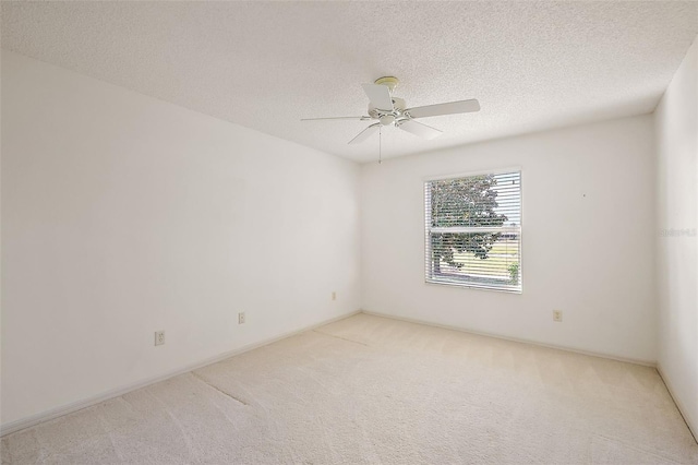 carpeted empty room with a ceiling fan and a textured ceiling