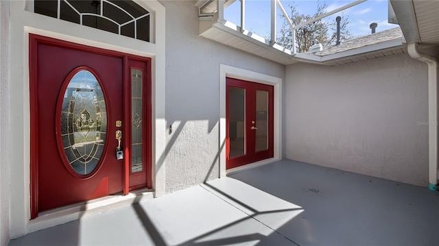 entrance to property with roof with shingles and stucco siding