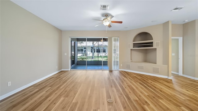 unfurnished living room with built in features, visible vents, light wood-style floors, a ceiling fan, and baseboards