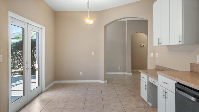 kitchen featuring arched walkways, light countertops, hanging light fixtures, white cabinetry, and dishwasher