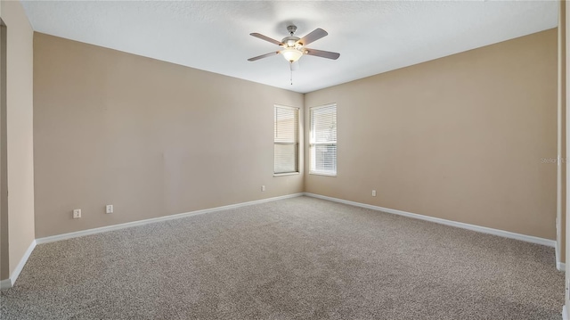 unfurnished room with ceiling fan, baseboards, and carpet flooring