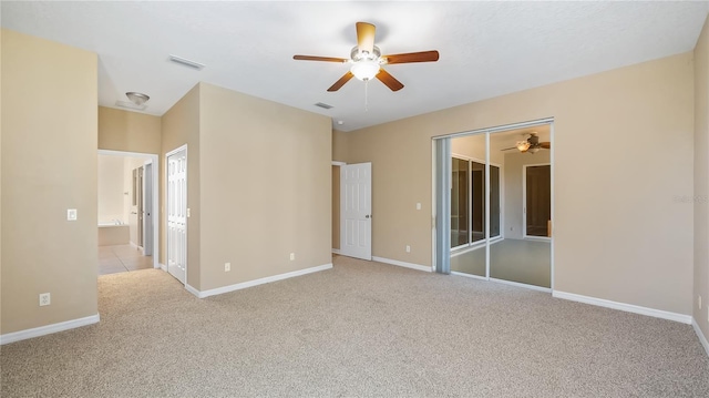 unfurnished bedroom featuring carpet floors, a ceiling fan, visible vents, and baseboards