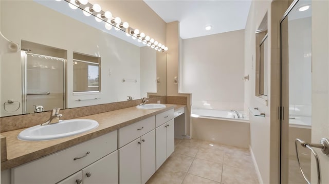 bathroom with a shower stall, a sink, and tile patterned floors