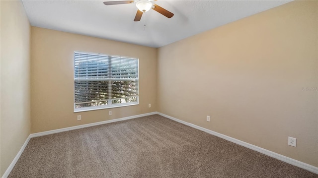 empty room with carpet flooring, ceiling fan, and baseboards