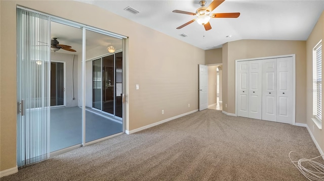 unfurnished bedroom with lofted ceiling, carpet floors, baseboards, and visible vents