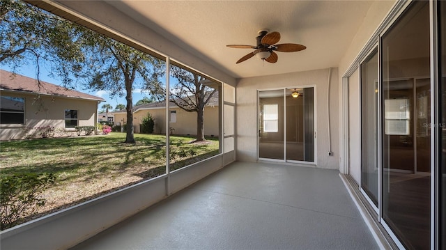 unfurnished sunroom featuring ceiling fan