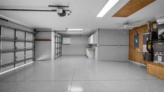 garage with concrete block wall, water heater, electric panel, and a garage door opener