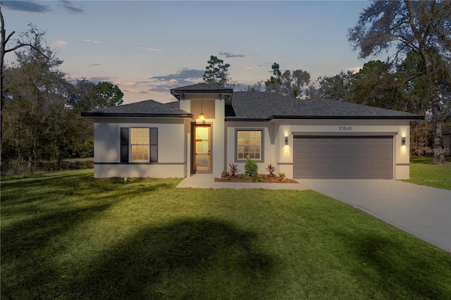 view of front of home with a garage, a shingled roof, driveway, stucco siding, and a front yard