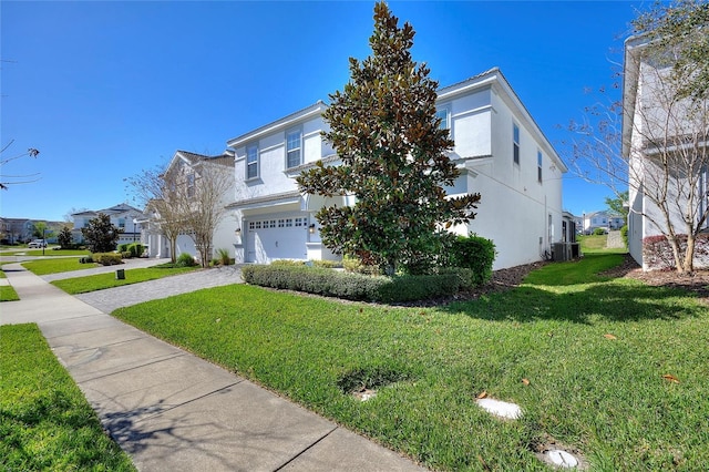 view of front of home with a front yard, decorative driveway, and stucco siding