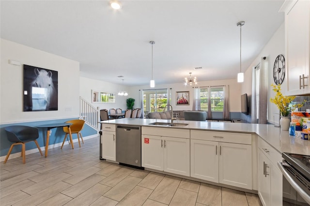 kitchen with stainless steel appliances, a sink, a peninsula, and an inviting chandelier