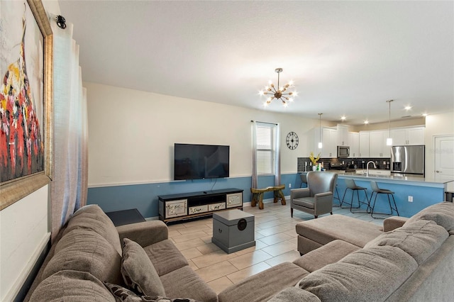 living area featuring light tile patterned floors, baseboards, and a chandelier