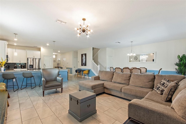 living room featuring visible vents, a notable chandelier, stairway, and light tile patterned flooring