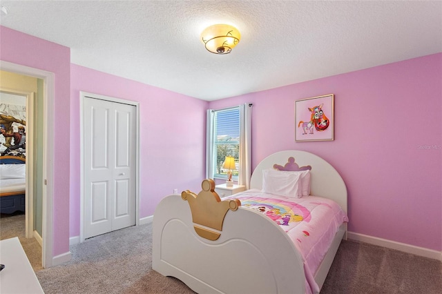 bedroom featuring a textured ceiling, a closet, carpet flooring, and baseboards