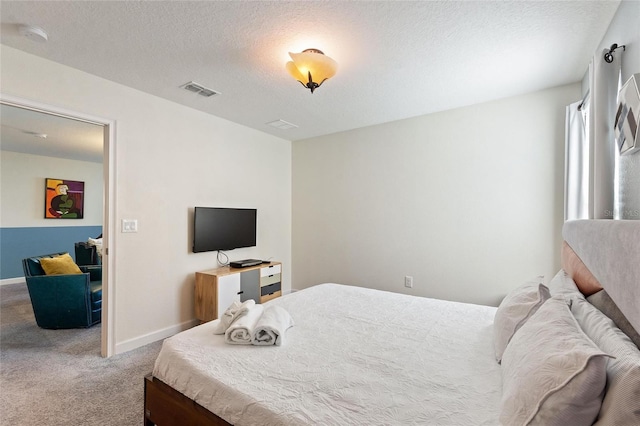 bedroom with visible vents, a textured ceiling, baseboards, and carpet flooring