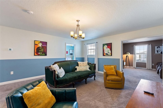 living area with a healthy amount of sunlight, baseboards, carpet floors, and a notable chandelier