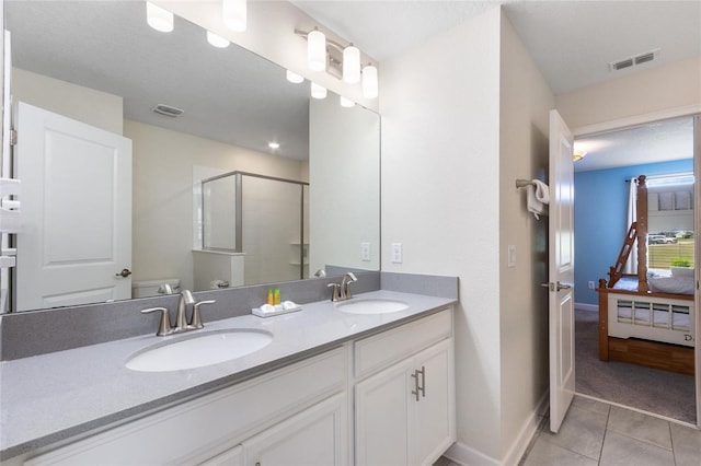 bathroom with tile patterned flooring, toilet, a sink, visible vents, and a stall shower