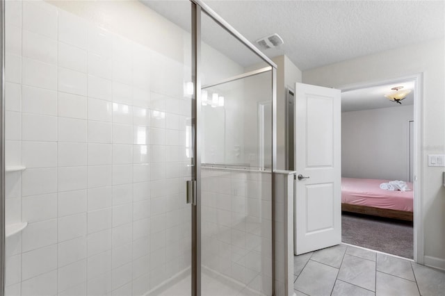 bathroom with visible vents, ensuite bathroom, tile patterned flooring, a textured ceiling, and a shower stall